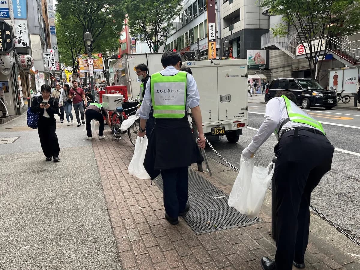 「まちをきれいに」と書かれたベストを着て清掃活動する参加者