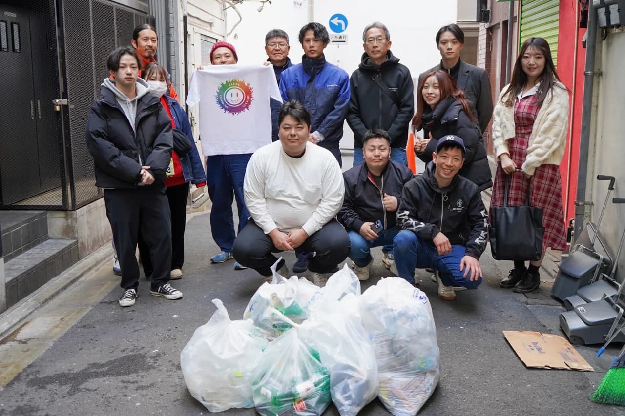 渋谷の路地でごみ袋を前に集合写真を撮るボランティア参加者たち